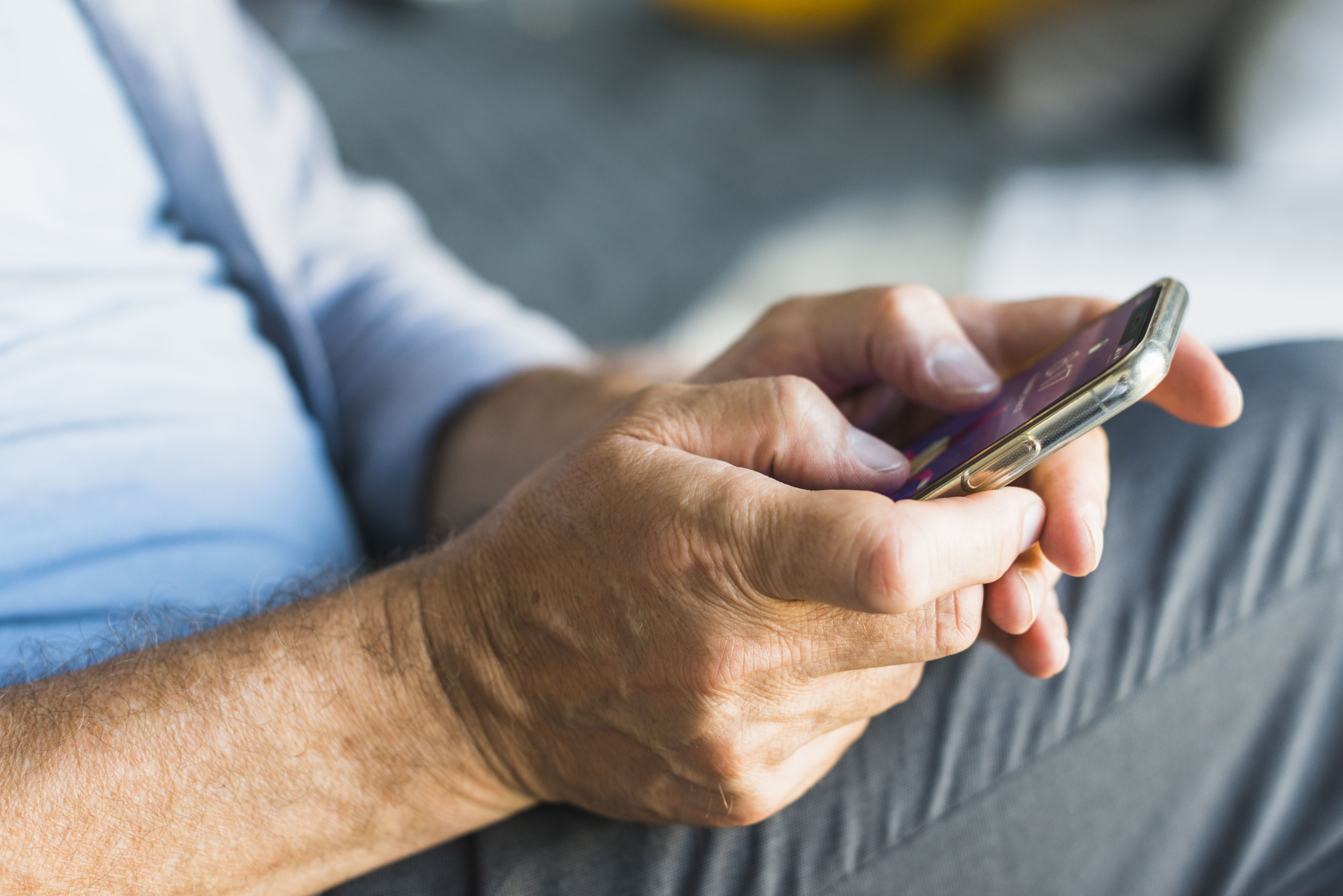 primer-plano-de-la-mano-del-hombre-mayor-de-navegacion-en-el-telefono-movil(1)